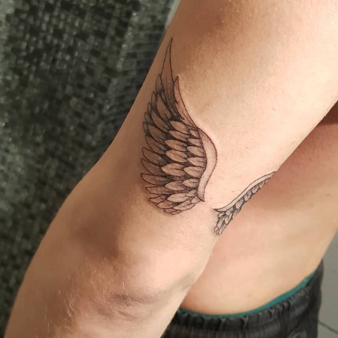 freshly inked wing tattoo on male ankle Stock Photo - Alamy